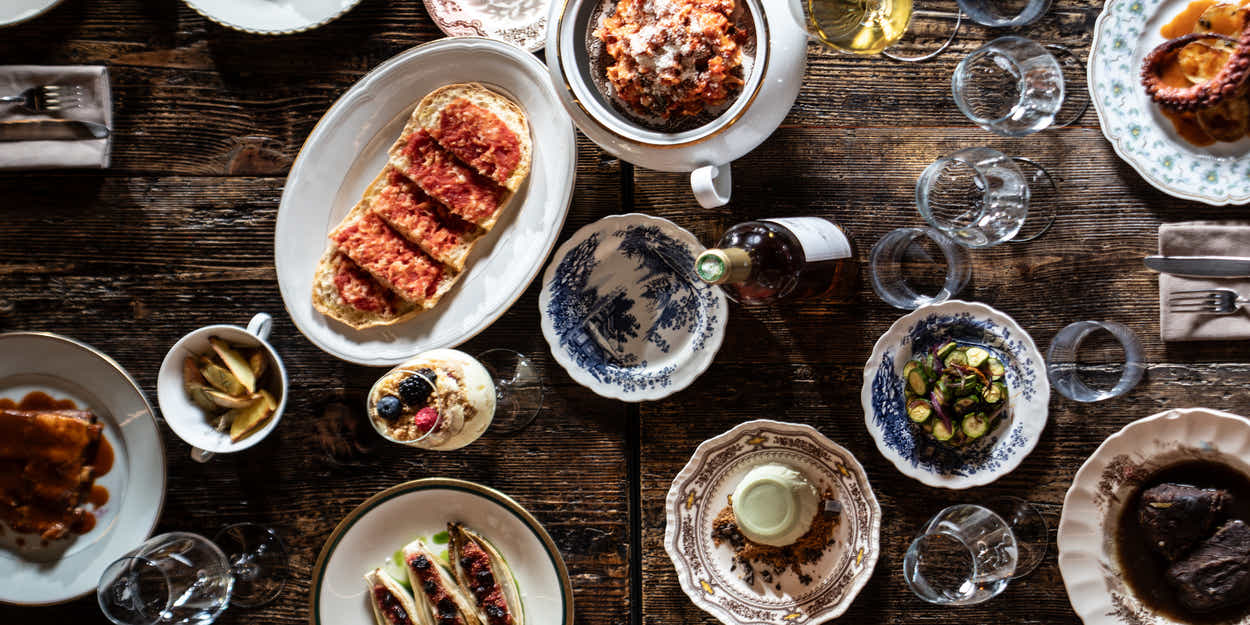 Een tafel bij Tomkat van bovenaf, met tomatenfocaccia, vleeswaren, octopus en veel gerechten om te delen